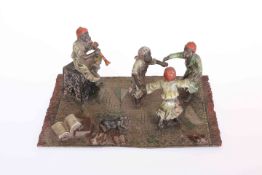 A COLD PAINTED BRONZE GROUP, three children dance to the tune of a flautist,