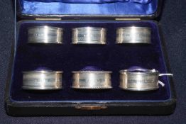 Cased set of six Edwardian silver napkin rings with vacant cartouche,