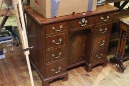 Mahogany kneehole desk having three frieze drawers above drawers and central cupboard