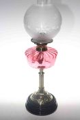 Brass oil lamp with ruby glass reservoir and frosted shade