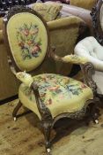 Victorian walnut open armchair with oval carved and needlework panel back