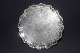 Edwardian silver salver with engraved decoration and ornate monogram to centre, on scroll feet,
