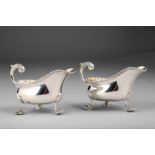 Pair George V silver sauce boats, scroll handle with acanthus leaf, each raised on three scallop