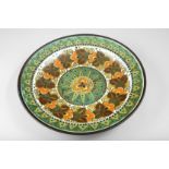 Gouda Pottery Charger, decorated in green, orange and brown enamels, 43cm diameter