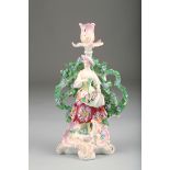 19th Century English porcelain bocage figure candlestick, shepherdess with a lamb, raised on a