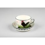 Wemyss Ware cup and saucer, hand painted with a black cockerel and titled ‘Bon Jour’ incised Wemyss,