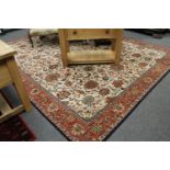 An Indian carpet, with an allover design of vines on a cream central field,