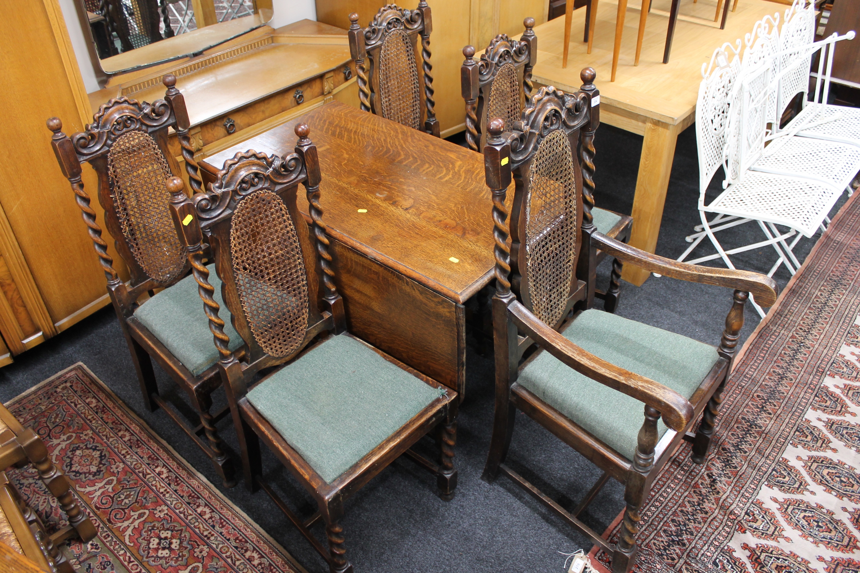 An early twentieth century oak drop leaf barley twist dining table together with a set of five