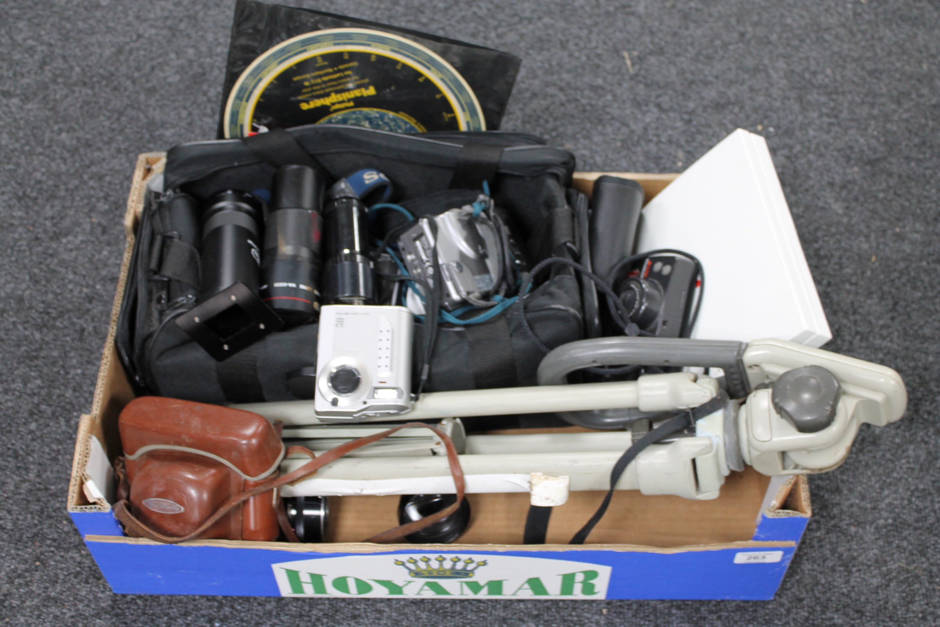 A box of camera bag and tripod, assorted digital cameras, telephoto lens,