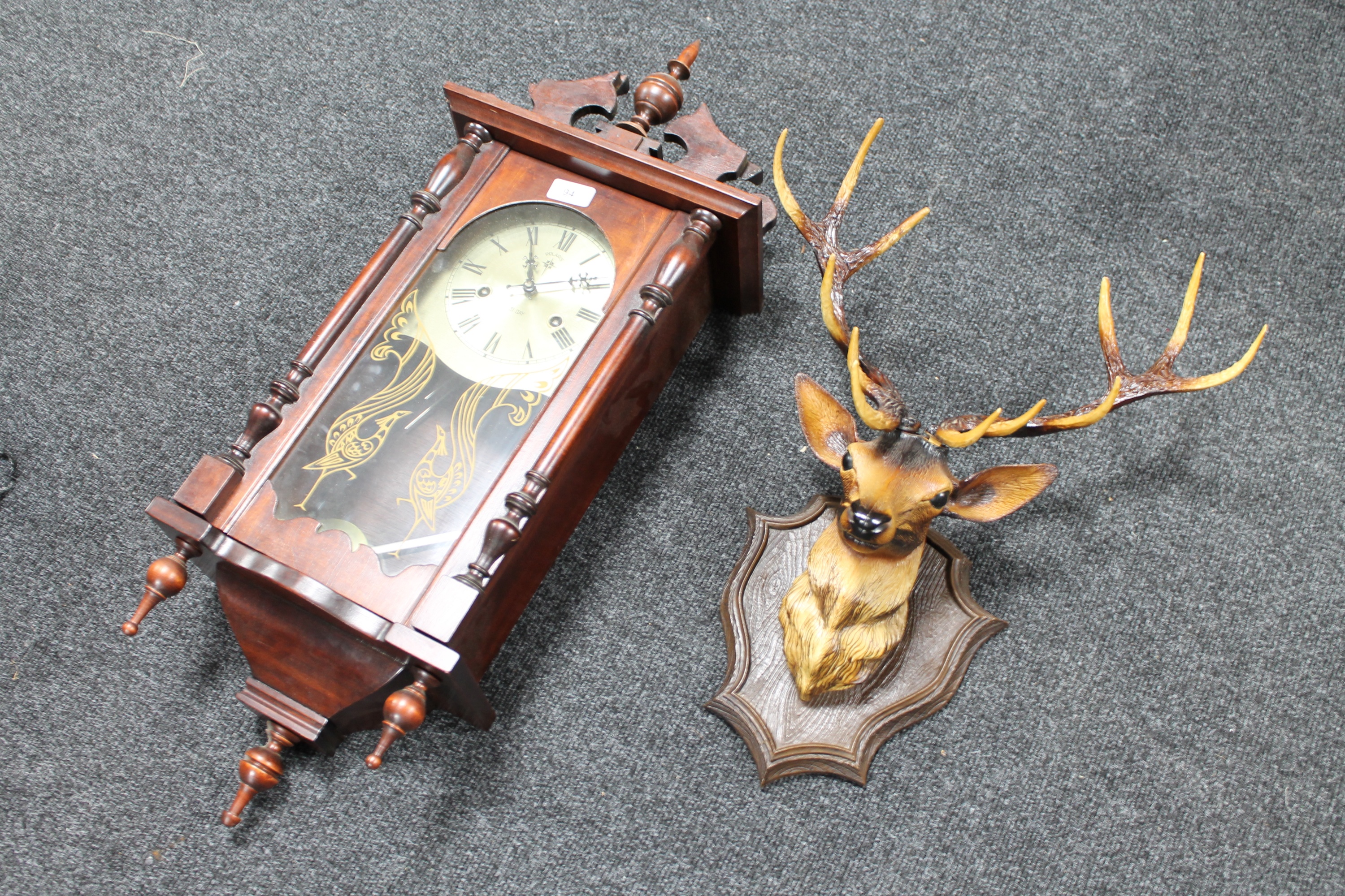 A Polaris 31 day wall clock and a plastic deer's head
