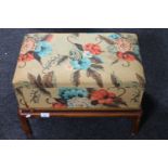 A twentieth century upholstered storage foot stool on pine legs