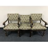 A pair of carved oak armchairs in tapestry fabric and a single chair