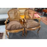 A pair of carved walnut bergere back armchairs