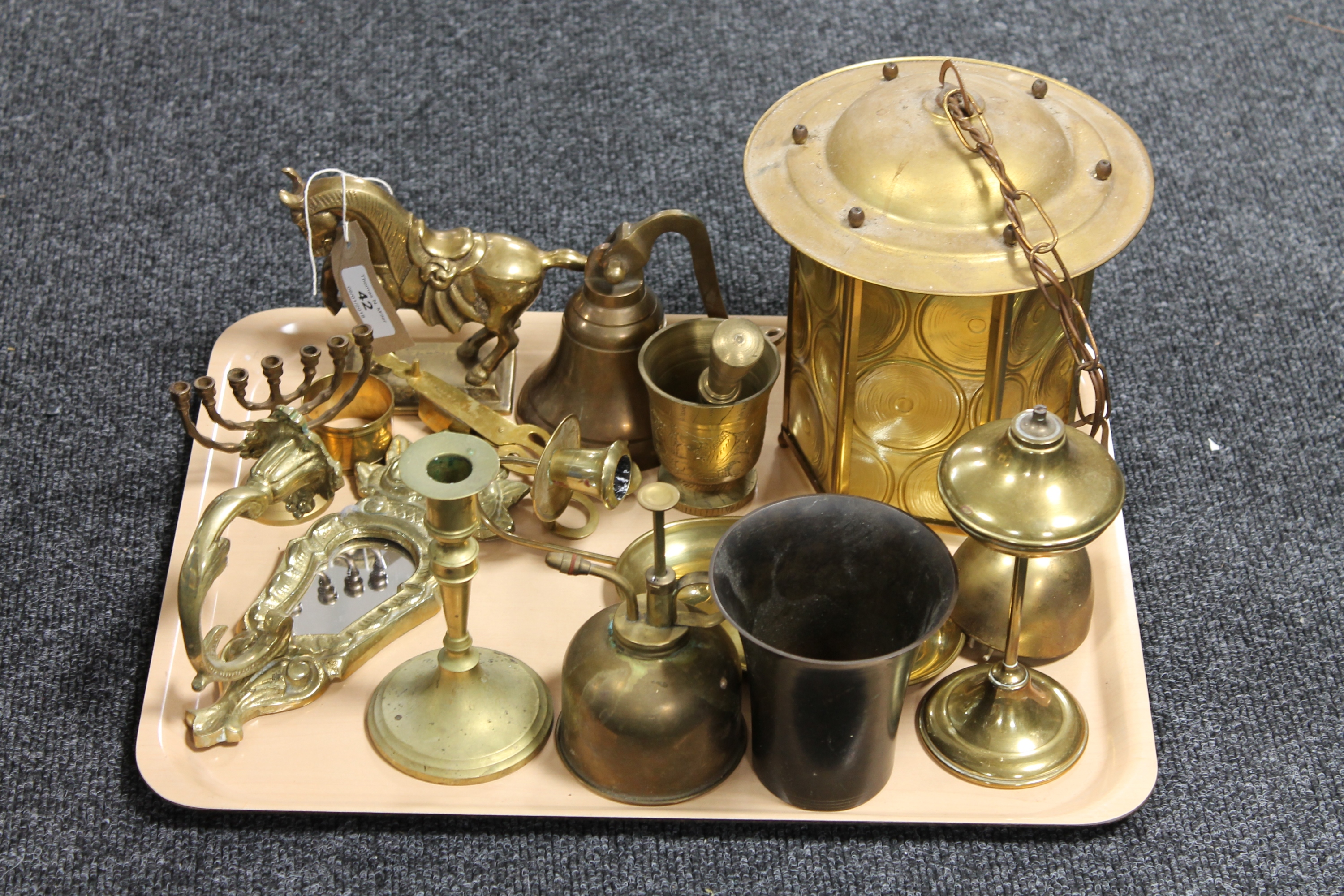 A tray of brass ware - bell, oil lamp, pestle and mortar,