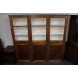An early twentieth century pine triple door kitchen cabinet fitted with cupboards beneath