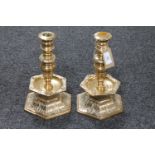 A pair of heavy brass candelabra on hexagonal bases,