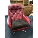 A 1960's red vinyl swivel armchair on chrome base