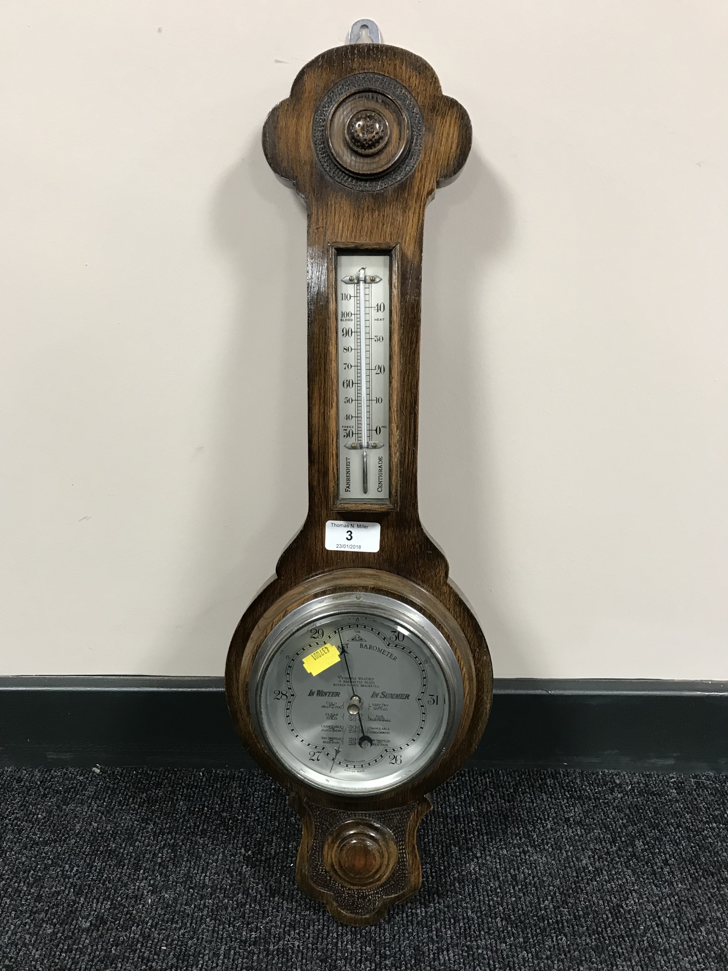 An oak cased barometer with silvered dial.