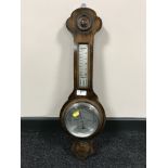 An oak cased barometer with silvered dial.