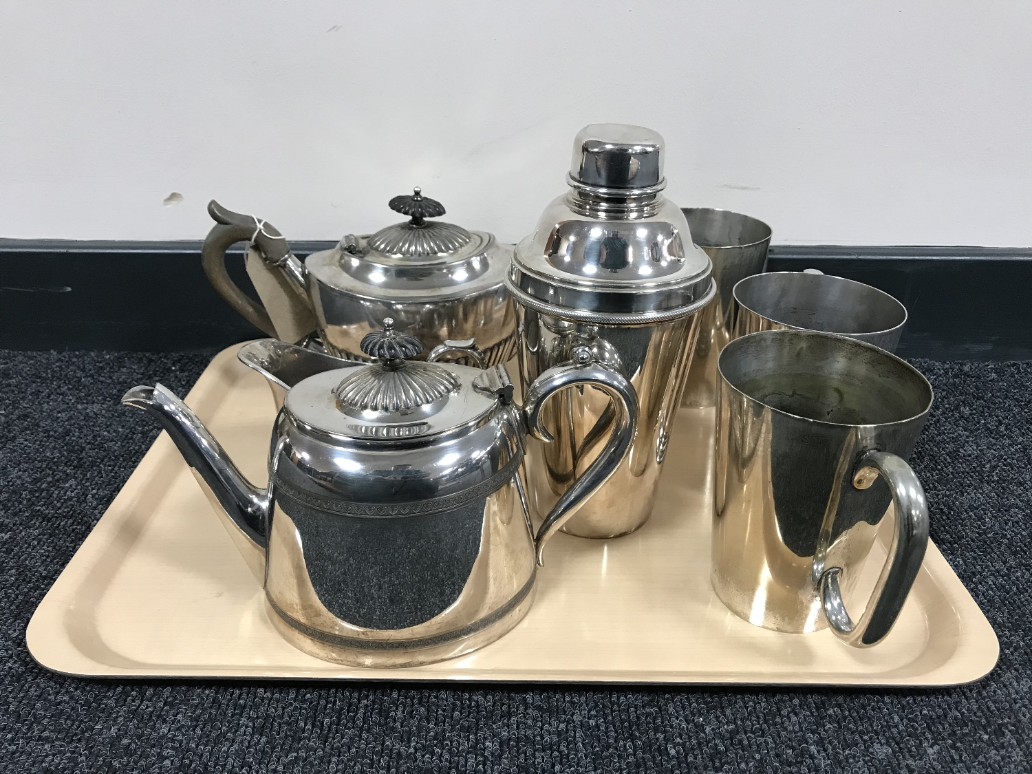 A tray of plated tea service, cocktail shaker and three plated tankards.
