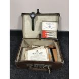 A vintage leather case containing ephemera, darts, monochrome photographs, miniature oil can,