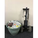 A tub containing a large quantity of golf balls together with a folding golf trolley