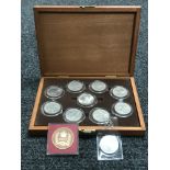 A coin box containing nine commemorative crowns and two other coins