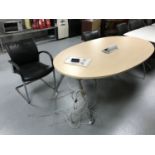 An oval office table with power points and two chrome office armchairs