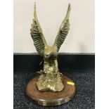 A brass American Bald Eagle ornament on wooden base