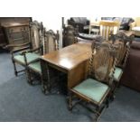 An early twentieth century oak drop leaf barley twist dining table together with a set of five