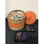 A wicker sewing basket and two Singer tins of sewing machine accessories