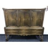 A twentieth century oak triple door sideboard fitted with six drawers