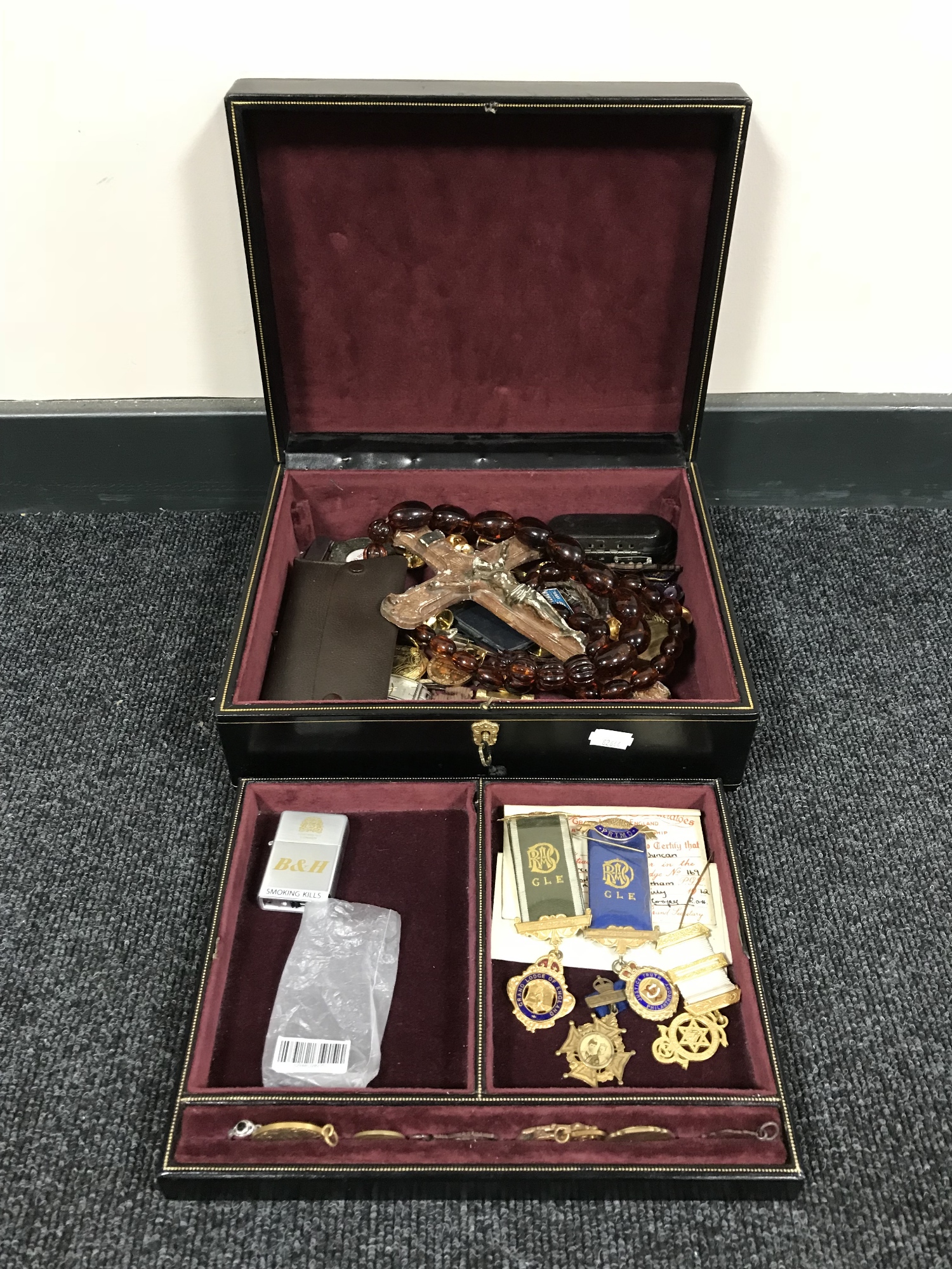 A black leather jewellery box containing costume jewellery, crucifix, sports medals,