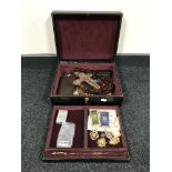 A black leather jewellery box containing costume jewellery, crucifix, sports medals,