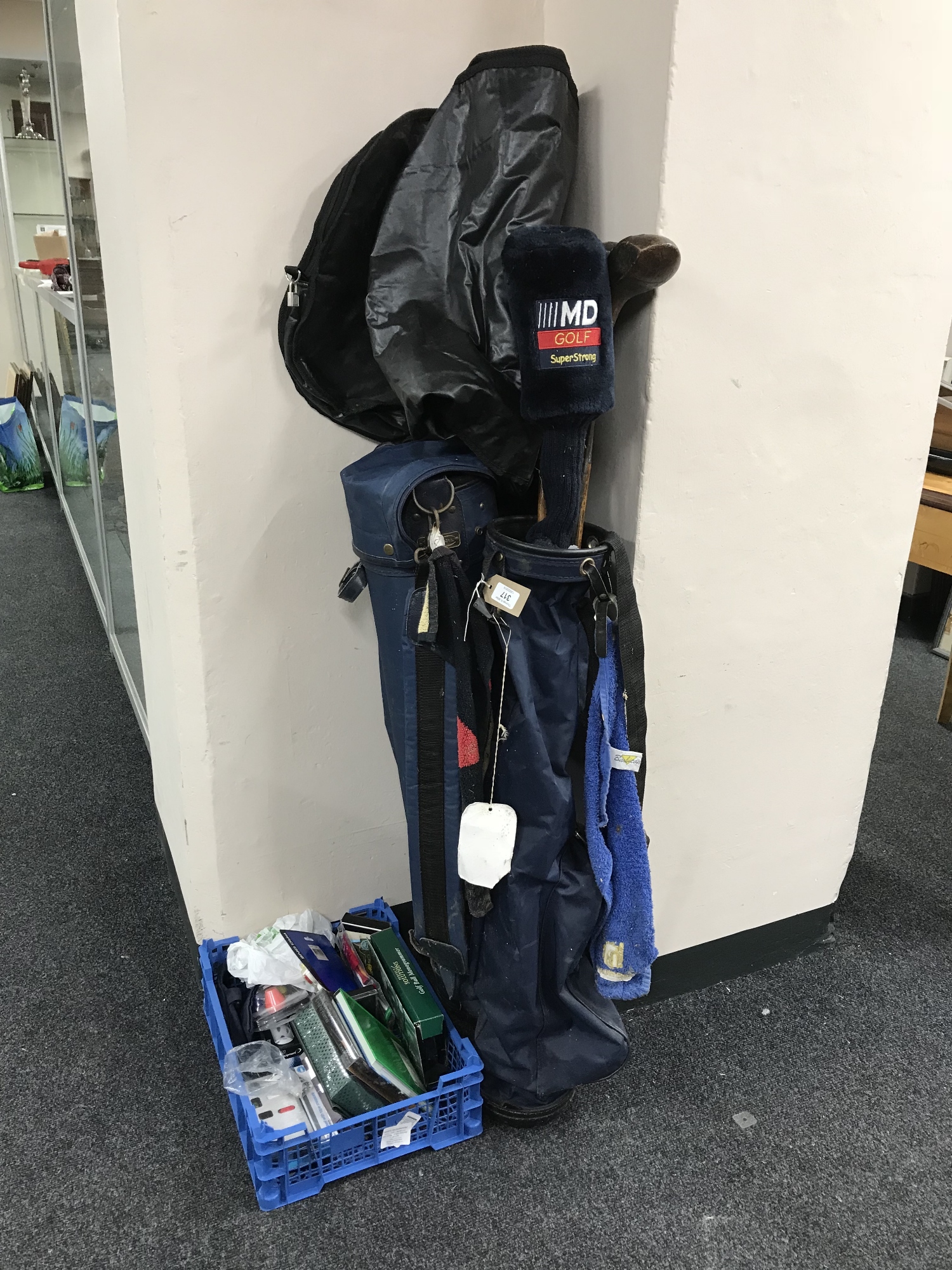 Two golf bags containing three hickory shaft drivers, three irons, golfing novelties, ball markers,