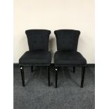 A pair of black upholstered button back chairs