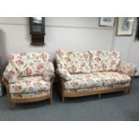 An Ercol three seater settee with matching armchair upholstered in floral fabric