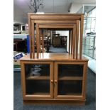 A nest of three late 20th century teak tables and a Meredew double door cabinet