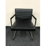 A contemporary chrome framed black leather armchair