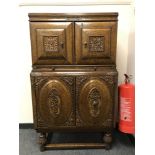 An early 20th century carved oak cocktail cabinet with slide and double cupboards,