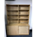 A late 20th century set of teak shelves with cupboard below