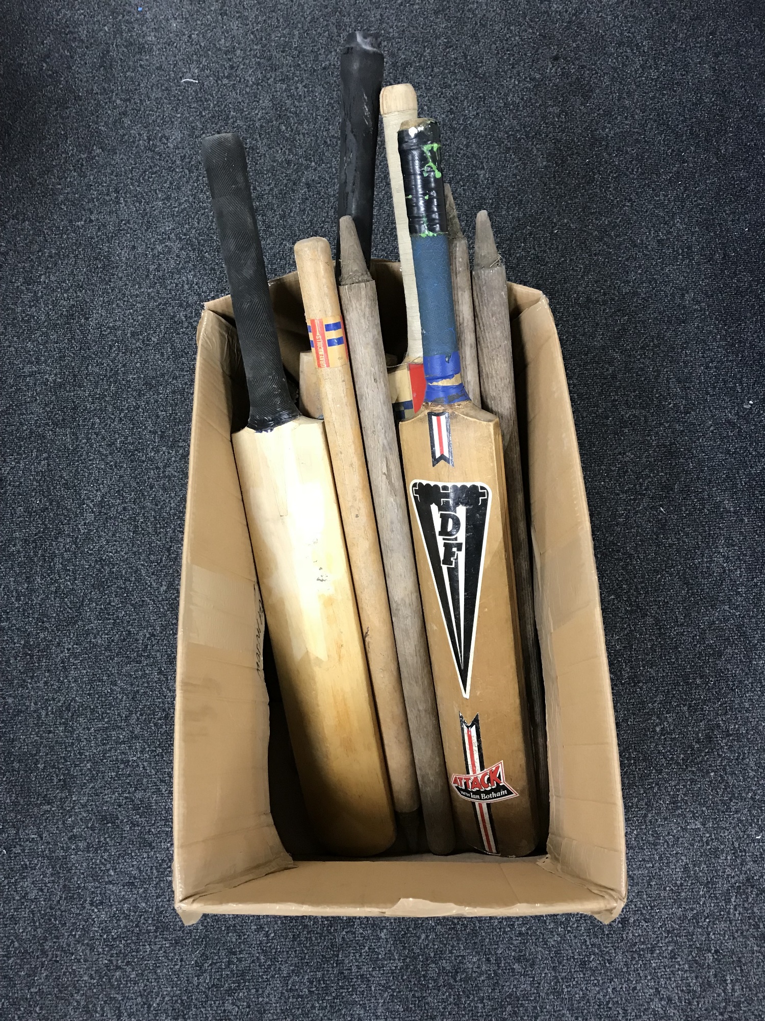 A box of cricket bats and stumps
