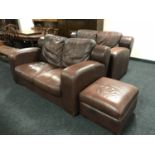 A pair of brown leather two-seater settees with matching footstool
