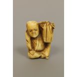 A Japanese ivory netsuke depicting a seated gentleman,