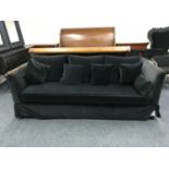 A contemporary bed settee in a black fabric with scatter cushions