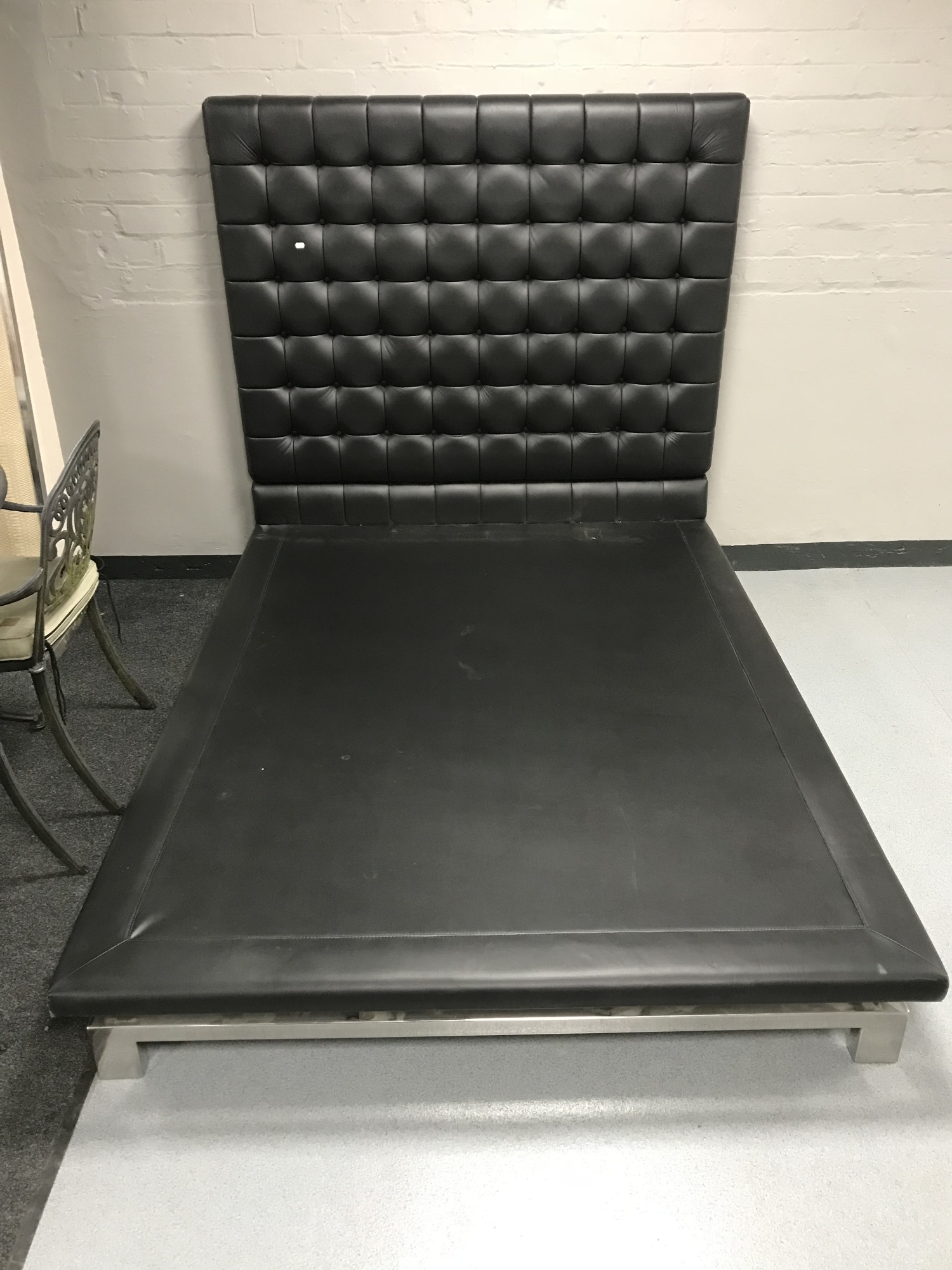 A contemporary black button leather 4'6 bed frame on metal legs