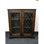 An oak leaded glass door bookcase