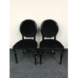 A pair of black upholstered salon chairs