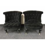 A pair of contemporary button back bedroom chairs in black fabric