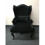 A contemporary wing back armchair in black fabric